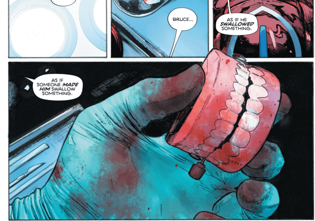 A hand in a bloodied surgical glove holds a set of toy teeth